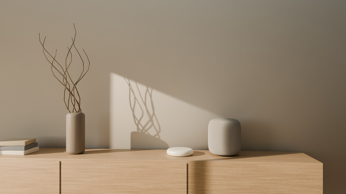 Morning sun across a living-room wall, an aaro one in Pearl on an oak sideboard beside a vase of dry branches