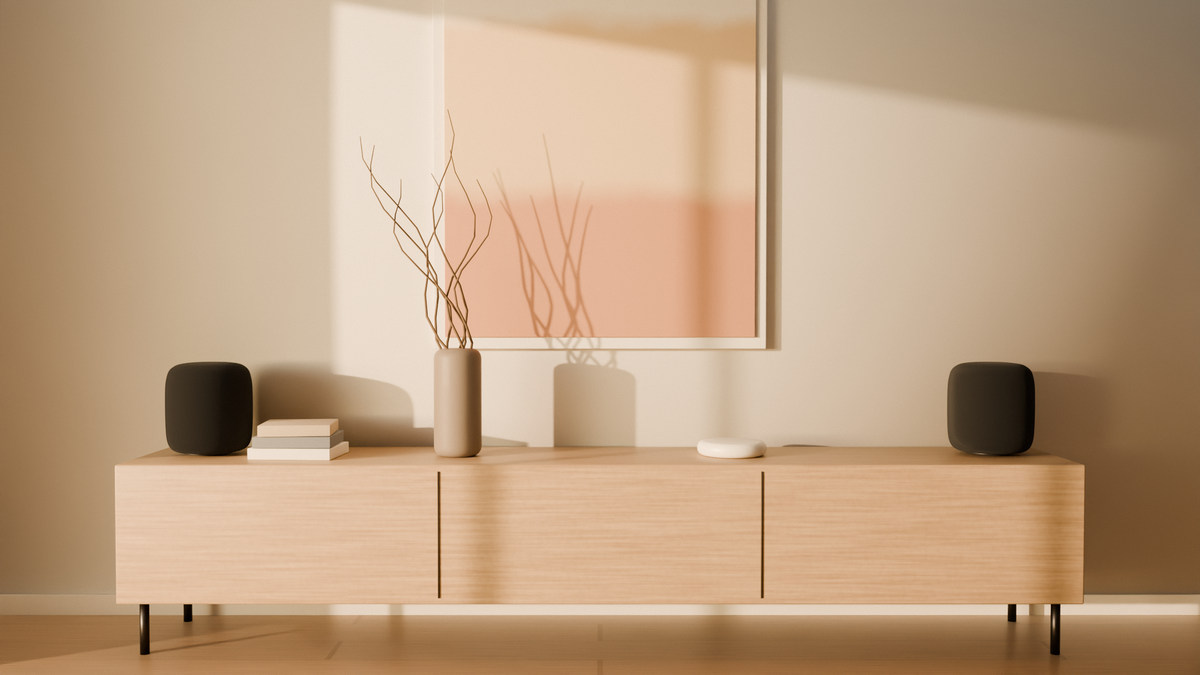 Low evening sun across the living room wall, a stereo pair of aaro one in Graphite at either end of an oak sideboard